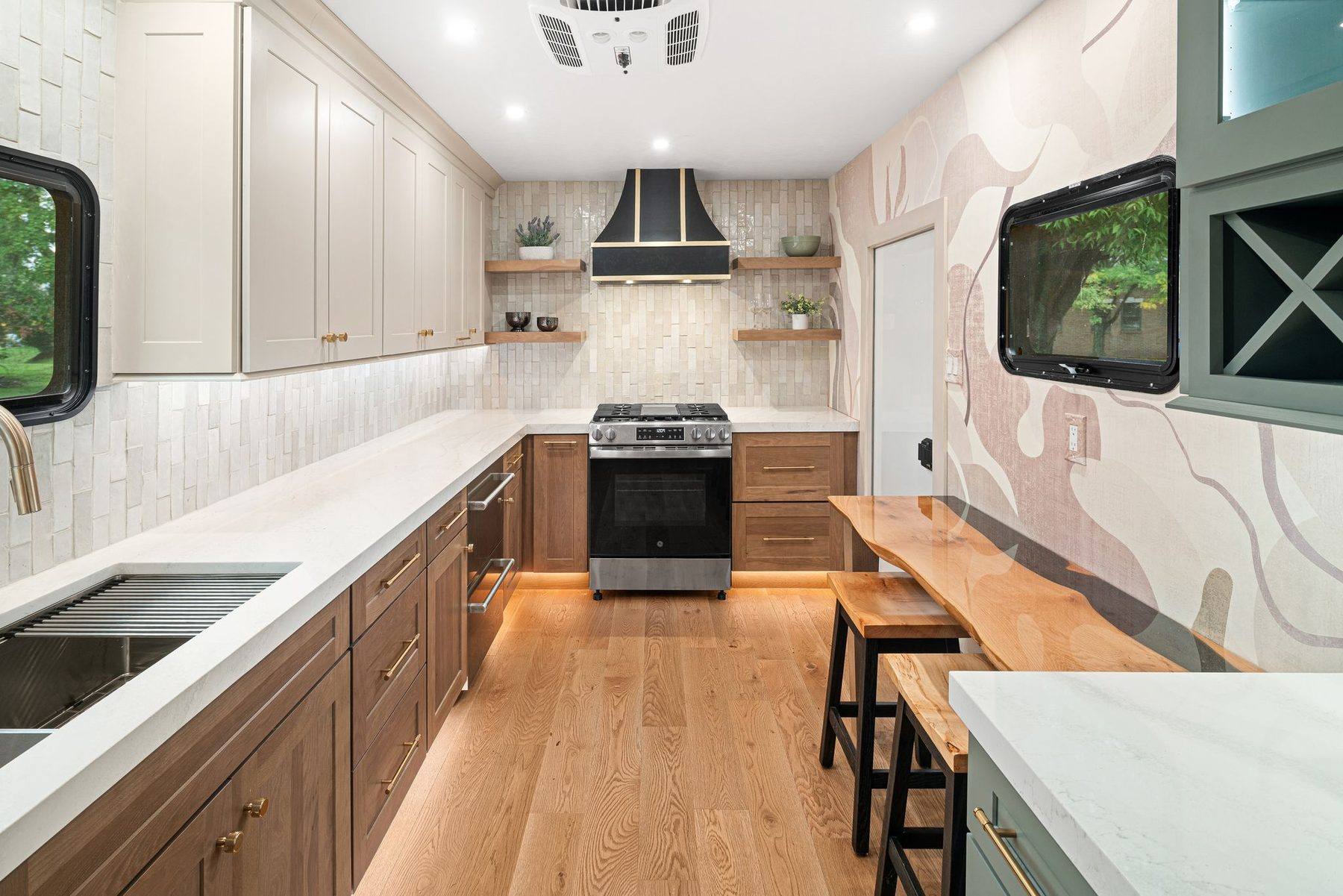 Finished Kitchen Condo interior with range, sink, cabinetry, and live-edge seating